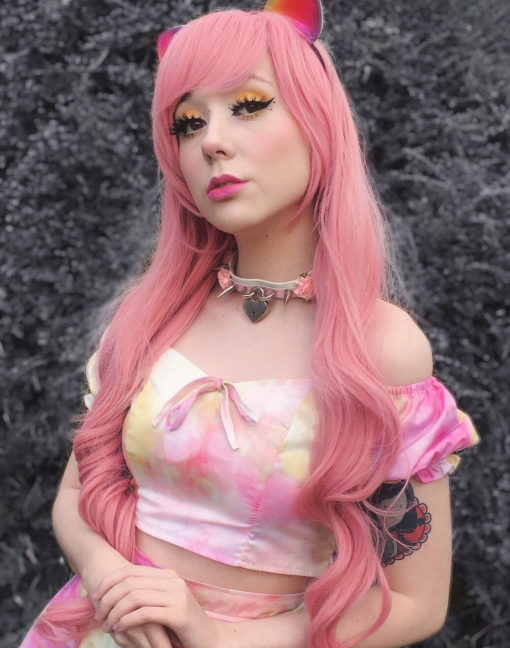 Pink long wavy wig with bangs. Candy girl is sweet and cute, with a deep pastel pink colour from roots to tips. A jaw skimming thick fringe goes with this sleek and wavy style.