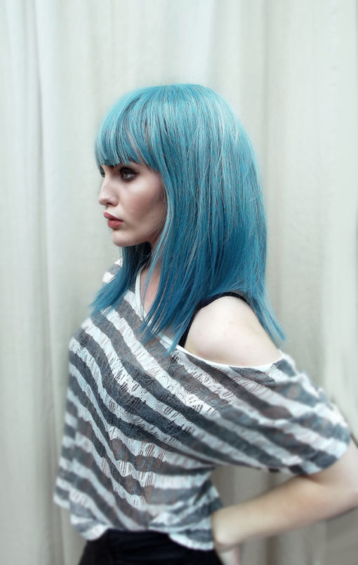 Green and blue long straight wig with bangs. Grunge comes in washed-out muted tones of teal with hues of pale blues from roots to ends. Sleek and poker straight.