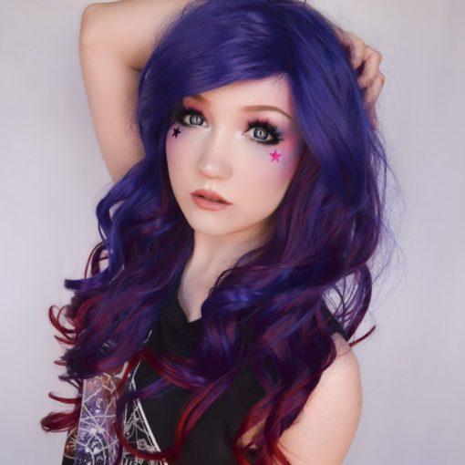 Purple and blue curly wig with bangs. Indigo carries a concoction of rich hues, starting with an indigo blue colour. That becomes loose curls with dark red highlights that run to the ends for a dip dye effect.
