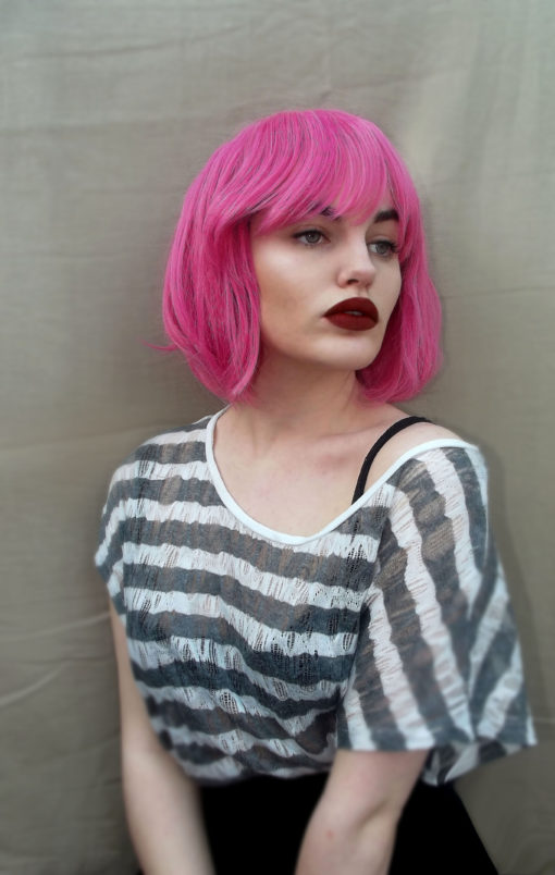 Cute bright pink bob wig with fringe. Milkshake brings us this vibrant fuscia pink colour, from roots to ends. A sleek graduated bob that falls just under the jawline. With a full fringe to add definition to the face. A style thats loud enough to stand on its own, or add intensity with accessories.
