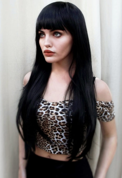 Black long wavy wig with bangs. Winter is a Midnight sky black colour. A barely there wave running through the lengths. With invisible layers cut in for extra volume.