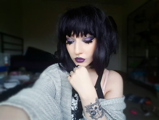 Black straight bob wig with bangs. Betty is a classic 1920s Bob style with a twist. A jet black tone with purple blocks of colour, for a peek-a boo effect. A graduated cut that just falls past the jawline. Complete the look with dramatic makeup.