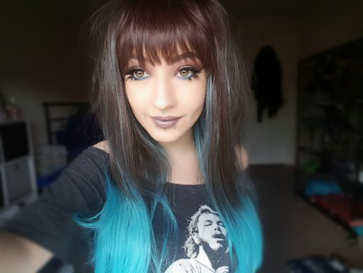 Brown and blue long straight wig with bangs. We are feeling mystic with Blue moon. A sleek style that's brown with highlights of electric blue, into a blue ombre.