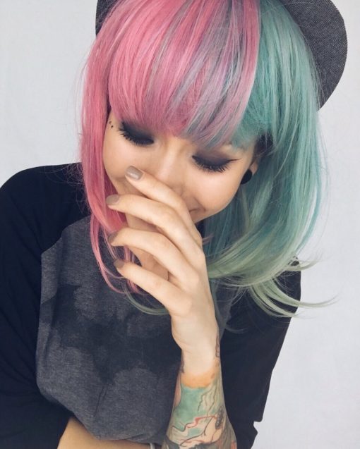 Candy split takes on the dramatic colour divide. With super cute pastel pink and green, the green melts into a faded fern tone on the ends. Split down the centre parting that carries the colour through the fringe. Sleek from the roots with a blow dry curl at the ends.