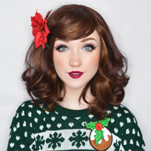 Film Star is a warm chestnut brown with golden highlights throughout. The style is sleek from the roots, ending in large curls. The bangs are sleek.