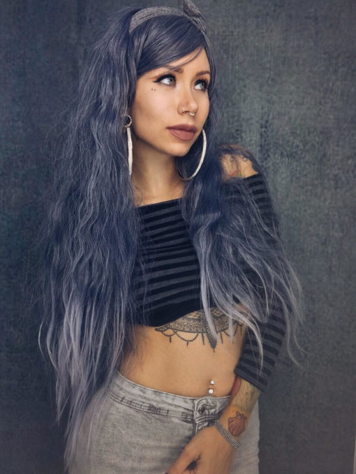 Blue grey long wavy wig with fringe. Are there fairies at the bottom of the garden? Grim Fairytale with its dark mix of grey highlights and indigo blue undertones, with crimped fluffy waves. Finished with dip-dye grey. 