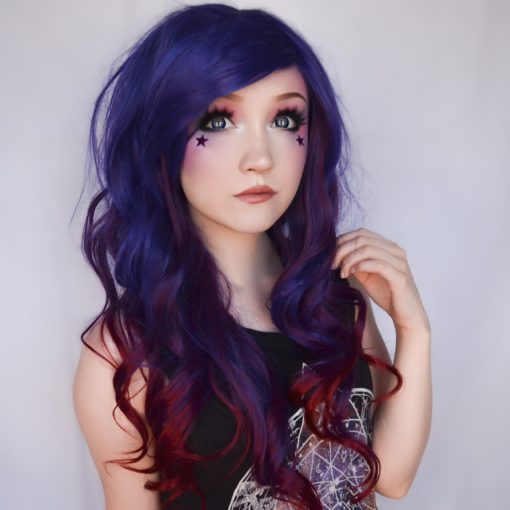 Indigo carries a concoction of rich hues, starting with an indigo blue colour. A full thick fringe allows you wear the style with extra layers. Long loose curls with dark red highlights that run to the ends for a dip dye effect. 