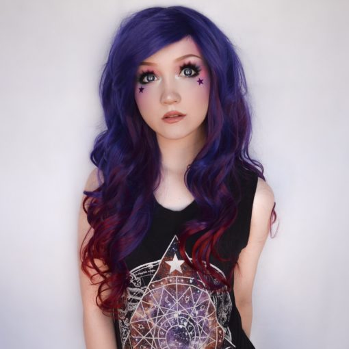 Purple and blue curly wig with bangs. Indigo carries a concoction of rich hues, starting with an indigo blue colour. That becomes loose curls with dark red highlights that run to the ends for a dip dye effect.