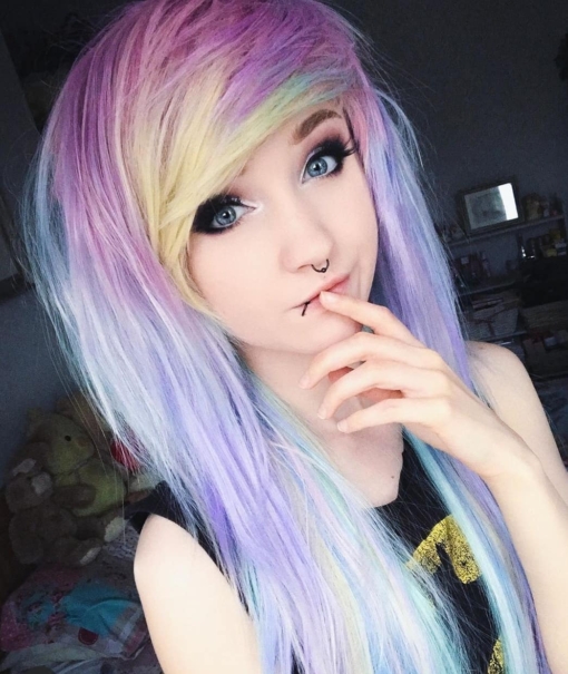 Multicolour pastel long straight wig with bangs. Candy sprinkles of pastel hues. Pink roots fade into a mix of yellow, blue, purple.