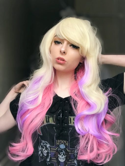 Blonde pastel long wavy wig with bangs. Sugar and spice and all things nice. Unicorn kisses locks pop with pretty pastels, of dreamy pinks and purples running through the barely there waves.