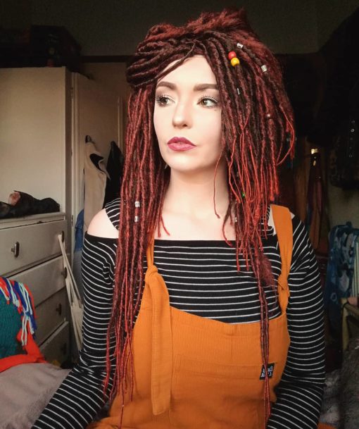 Our first dreadlock wig! Warrior Princess is a mixture of brown and bright red hair, styled into thin dreadlocks that fall in layers around the face, shoulders and chest. The wig has more volume of hair on the top, and works great styled in a half up/half down look.
