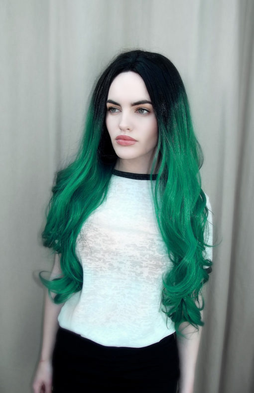 Green long wavy lace front wig. Forest Ombre certainly emulates earthy tones in this style. Dark black roots that run into a green ombre. Set with waves that end in cascading curls, that fall to the hips. Full of body and volume.