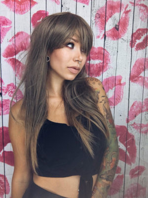 This wig has a mixture of sandy blonde and grey lowlights from the roots to ash blonde dip dye tips. Styled sleek with long layers falling to the waist. The fringe is long and sleek.