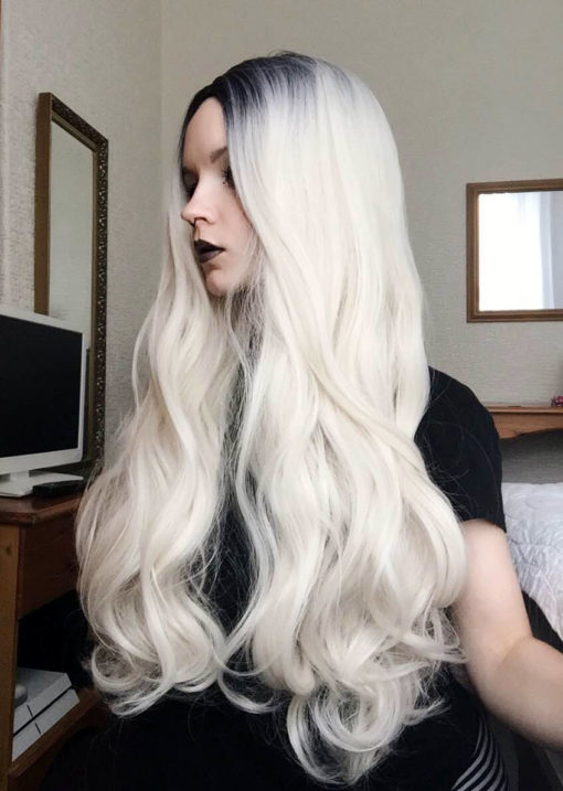 Dark roots fade from black/dark grey, into lighter grey and then bright white blonde. A beautiful long, middle parted wig, styled in curls through the ends.