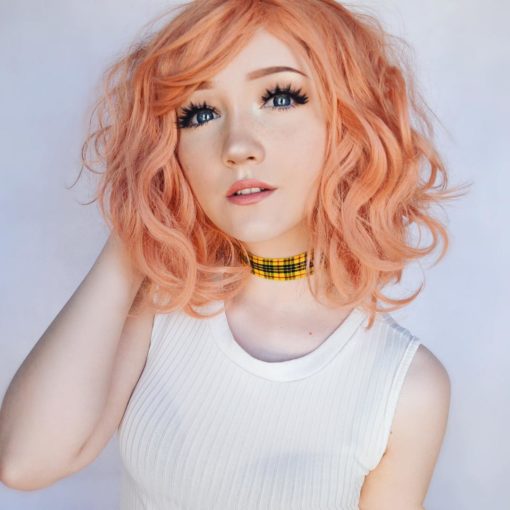 Peach wavy bob wig with bangs. Peach tea is a simple style that comes in a sweet peach shade. Styled in loose beachy waves for texture.