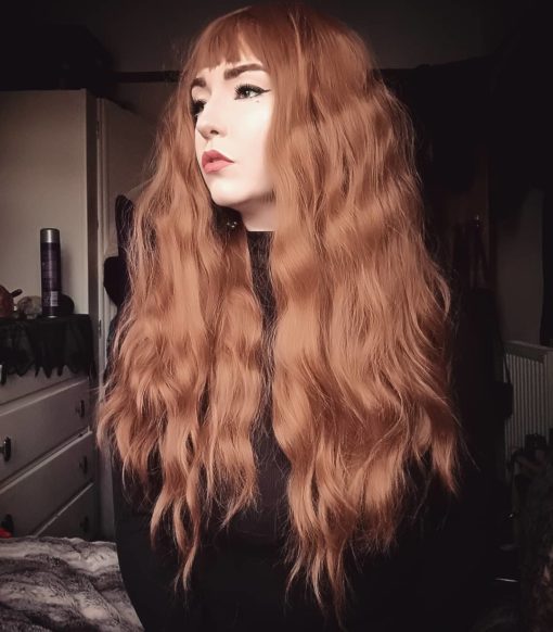 Amber long crimped wig with bangs. Katherine has a soft and natural look. The crimped, golden amber tones from roots to tips, are amplified creating loads of fullness.