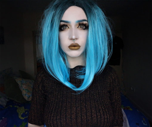 A sleek, blunt bob with black roots and a bright, electric blue dip-dye. Easy to wear, fringeless with a defined parting.