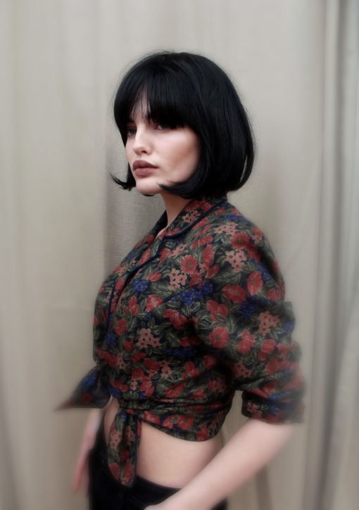 Jet black short bob wig. Step back in time to the 30s in Rue Morgue. Jet black short bob, blunt and chin length with a curl at the cheek. 