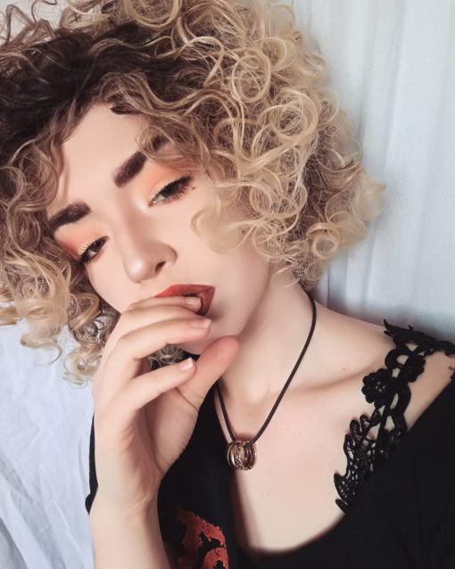 Blonde short curly wig. Calling all dancing queens! Stargaze is a vibrant and fresh style. Dark brown roots with ash blonde locks. This tight spiral curl wig is perfect for those who want to try a mop of curls without hours of styling!