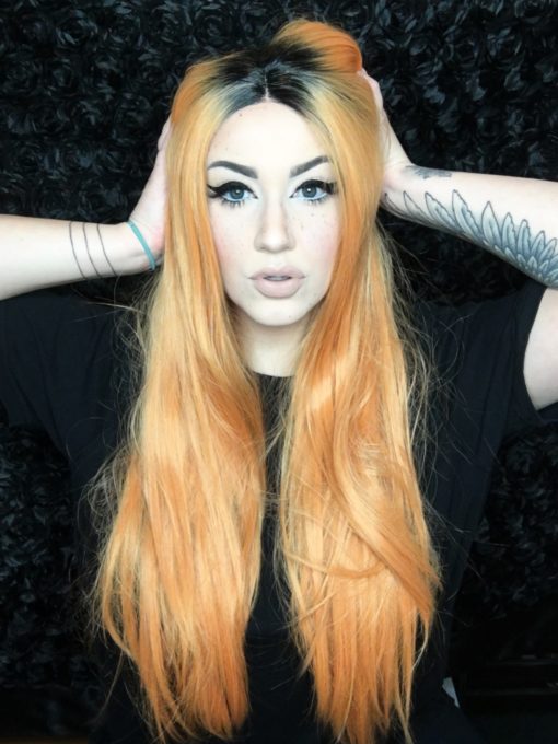 Gorgeous sleek Lace front in a washed-out orange shade. This wig is very versatile, can be worn messy and grungey or sleek and shiny for a more glam look. The black roots give it a natural feel, and the faded colour allows for bright hair that isn't too brazen.