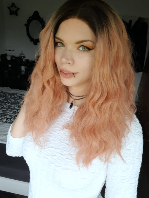 Peach long wavy lace front wig. Feminine and cool. Thunder comes with a natural twist of cool black roots that compliment the peachy rose gold undertones. Set in crimped waves creating lots of volume and bounce.