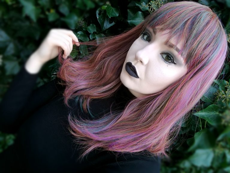 This Vivid wig is a mixture of purples, blues and muted lemon and green tones, from roots to tips. Styled sleek with long layers falling to the waist. The fringe is long and sleek, wear it to the side or parted for curtain bangs.