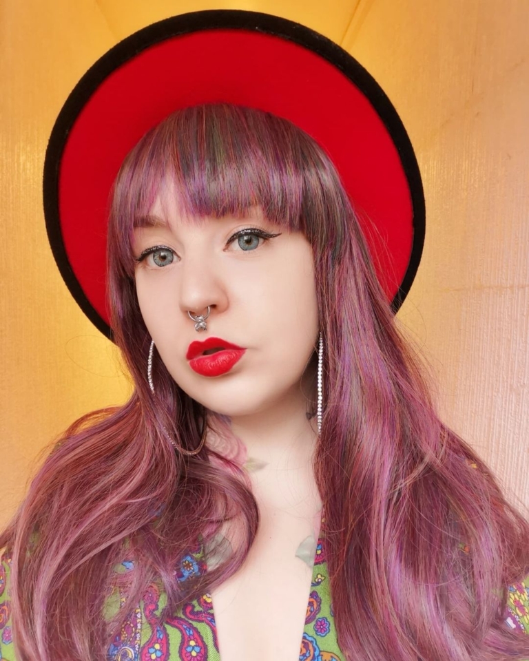 This Vivid wig is a mixture of purples, blues and muted lemon and green tones, from roots to tips. Styled sleek with long layers falling to the waist. The fringe is long and sleek, wear it to the side or parted for curtain bangs.