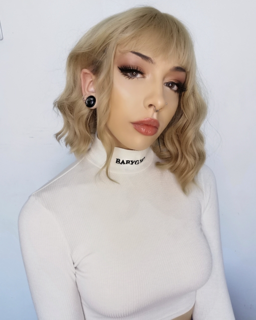 Blonde wavy bob wig with bangs. Milk Tea is a hit and one of our top trending natural wigs. A simple style that comes in a light blonde shade in tousled waves.