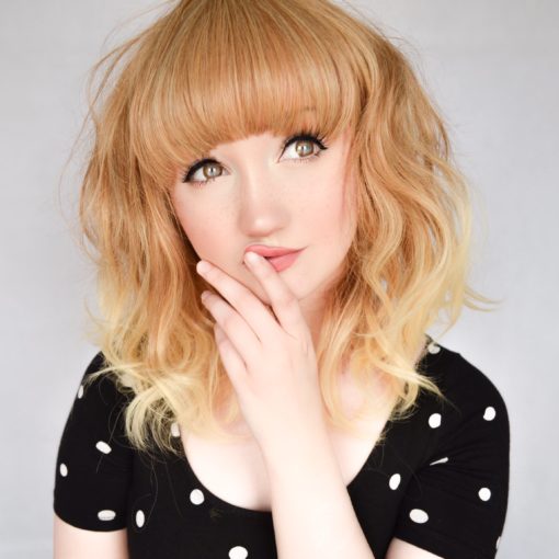 Blonde wavy long bob wig with bangs. Zoey has a soft and subtle natural look. Soft honey blonde and spicy mix of colour with light sun kissed dip dyed ends. With loose waves to give volume and movement that fall just above the shoulders. With a full blunt fringe to frame the face.