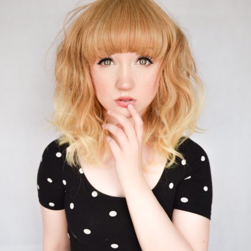 Blonde wavy long bob wig with bangs. Zoey has a soft and subtle natural look. Soft honey blonde and spicy mix of colour with light sun kissed dip dyed ends. With loose waves to give volume and movement that fall just above the shoulders. With a full blunt fringe to frame the face.