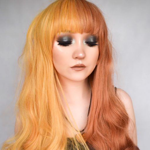 This dreamy split colour wig is super sweet! Light orange on one side, and a rich auburn colour on the other side, this style falls in loose curls at around bust-length. Finished with a heavy blunt fringe, that can be trimmed to suit the wearer.