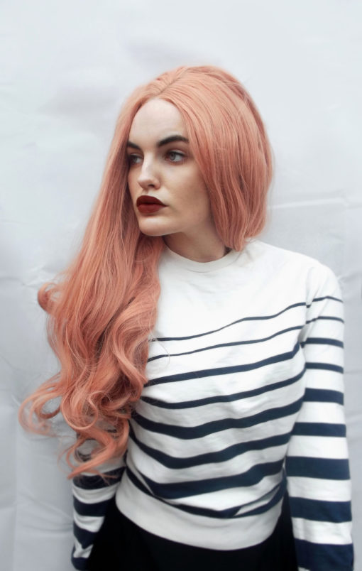 Pretty in peach! This pastel toned lace front style is a lovely vibrant peach colour from root to tip, with a realistic hairline and long, loose wavy curls that fall past the bust. Fit for a Pastel Princess!