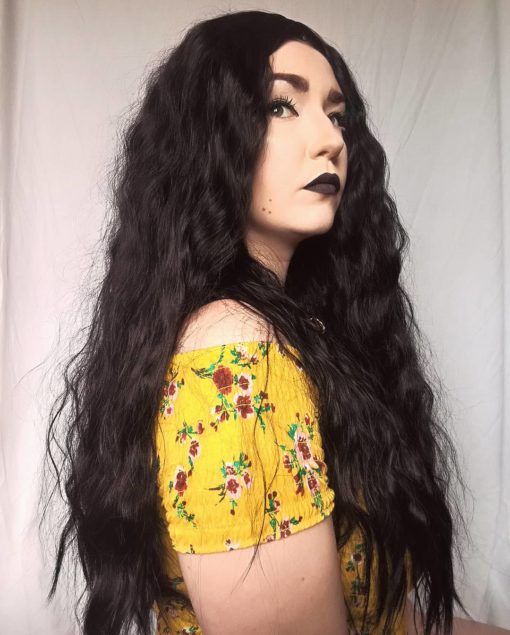Long wavy black wig with bangs. Getting seriously gothic vibes from Bellatrix! Jet black colour with added impact with amplified crimped waves makes it fluffy and full. A straight fringe frames the face. Perfect.