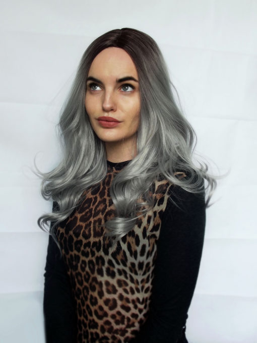 Penny with brown shadowed roots and a Silvery grey colour, sleek from the roots ending in loose curls. One of our favourite fringeless styles.  