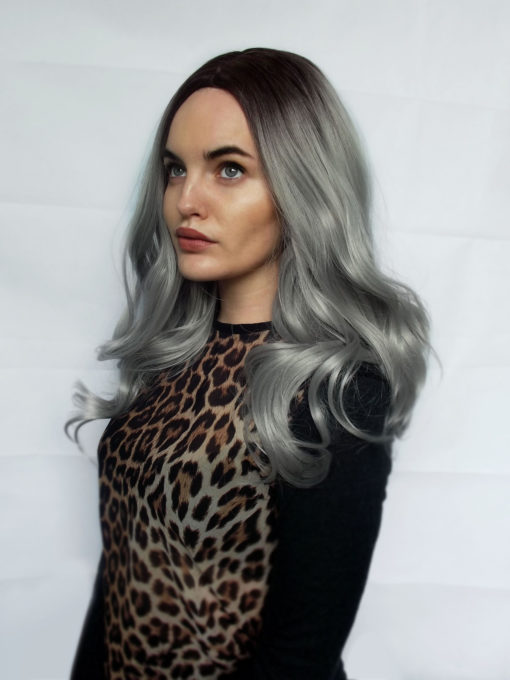 One of our fringeless grey styles with dark brown shadowed roots for a natural feel. A spellbinding Silver grey colour. The classic centre part is sleek from the roots and styled into a blow out for volume and bounce.