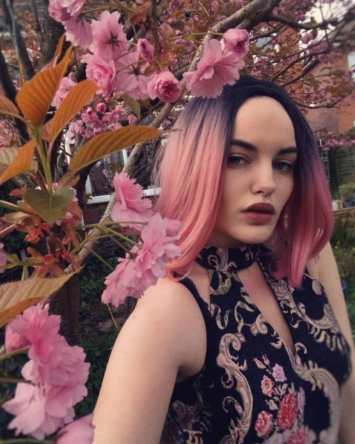 Rose pink straight bob with dark roots. XOXO takes pink hair to the next level with black shadowed roots that blend into a rose hue. As a classic chic bob, we can't get enough of it!