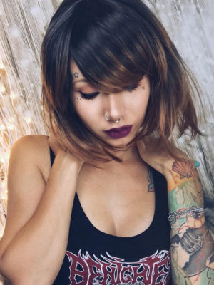 Lucia is a sleek bob that curls under at the ends. Falling to the jawline. This black/brown colour has highlights of copper tones that bring it to life. With a sleek full blunt fringe.