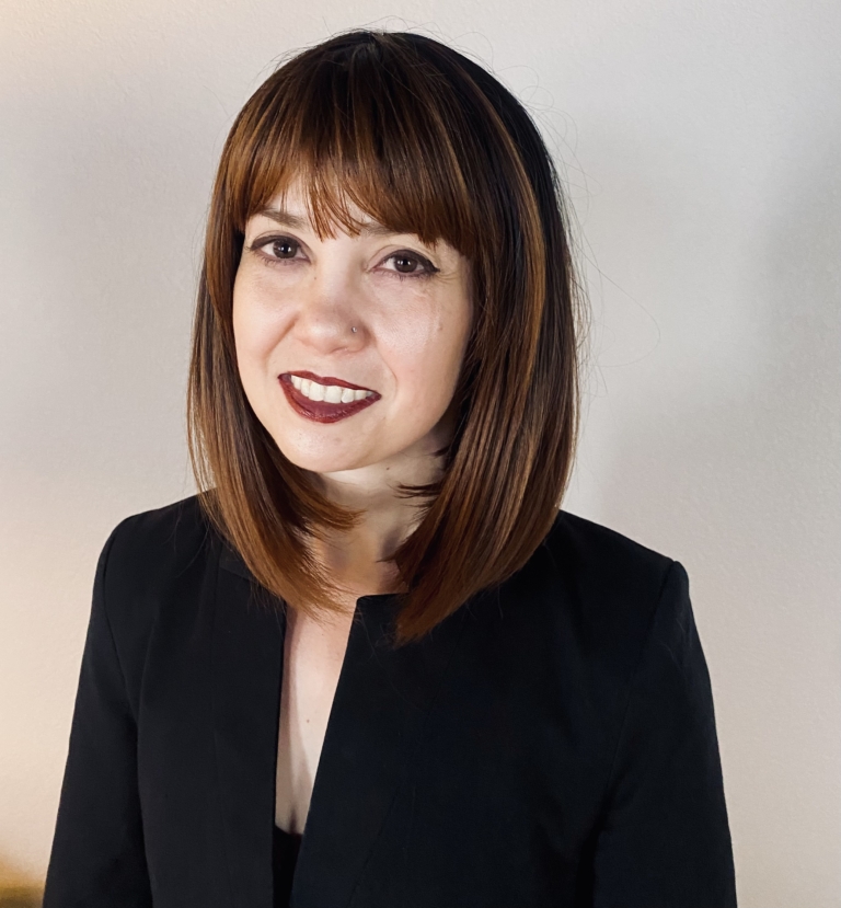 Lucia is a sleek bob that curls under at the ends. Falling to the jawline. This black/brown colour has highlights of copper tones that bring it to life. With a sleek full blunt fringe.