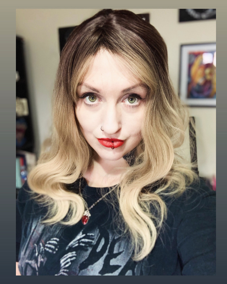 Eleri - Lush Wigs UK This long bob with dark brown shadow roots blend into a warm blonde hue. Styled in a loose wave with a sleek blunt fringe.