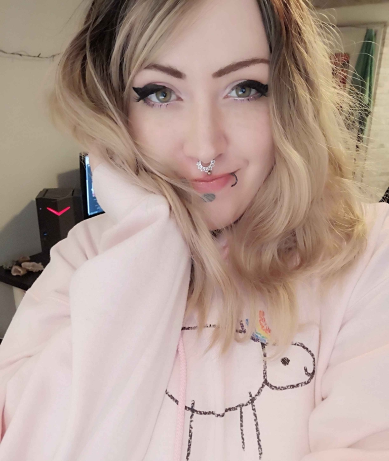 Eleri - Lush Wigs UK This long bob with dark brown shadow roots blend into a warm blonde hue. Styled in a loose wave with a sleek blunt fringe.