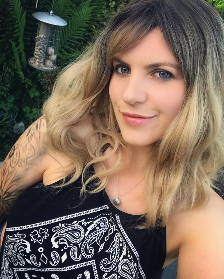 Eleri - Lush Wigs UK This long bob with dark brown shadow roots blend into a warm blonde hue. Styled in a loose wave with a sleek blunt fringe.