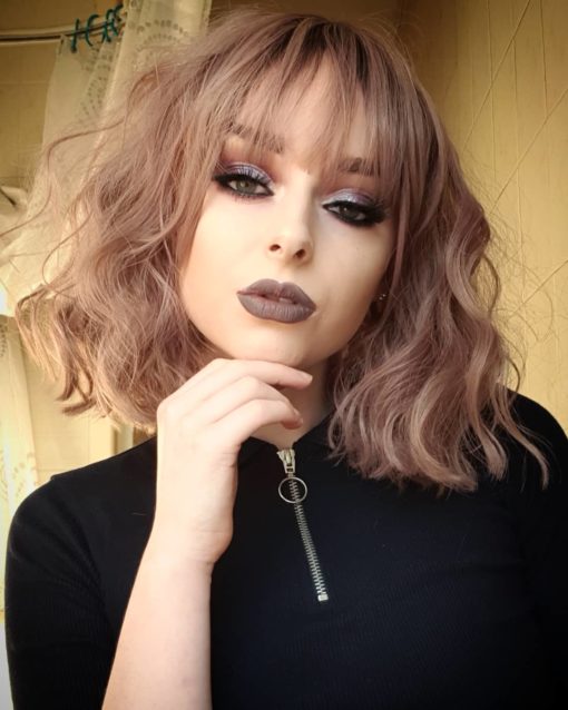 Blonde and lilac wavy bob wig with bangs. Rose jam is one of our favourite Bobs. Brown roots, that melt into a dusky pink shade. Reminiscent of a hint of tint with wavy blonde highlights.