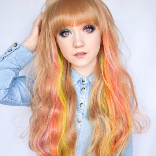Out of this world! Supernova is a strawberry blonde base with the brightest neon rainbow highlights running through it. So unusual! This quirky wig is finished in loose curls and falls past the bust. A perfect pop of colour!