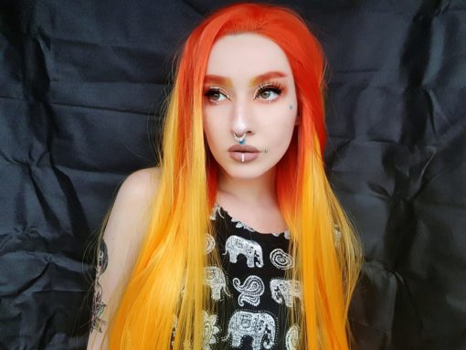 Long red and orange lace front ombre wig. Solstice is a bold concoction of colour, with bright red roots, yellow mid-lengths that melt into an orange ombre. This style is not for the faint-hearted, but that’s why we adore it!