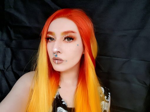 Long red and orange lace front ombre wig. Solstice is a bold concoction of colour, with bright red roots, yellow mid-lengths that melt into an orange ombre. This style is not for the faint-hearted, but that’s why we adore it!