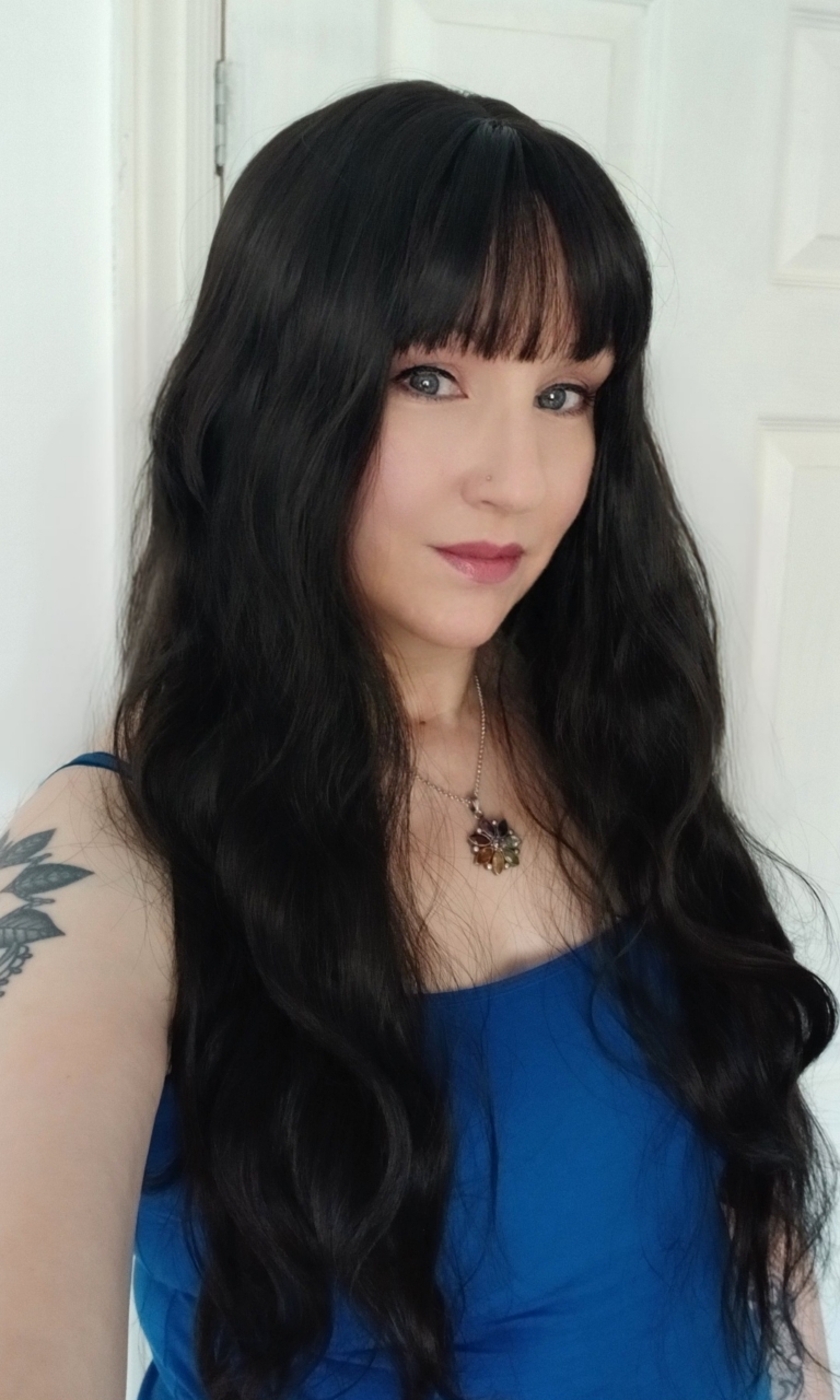 A very dark brown colour from roots to tips. Styled in loose waves that fall to the waist. Long invisible layers to add body and movement to the look. With a sleek blunt fringe.