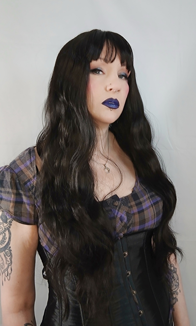 A very dark brown colour from roots to tips. Styled in loose waves that fall to the waist. Long invisible layers to add body and movement to the look. With a sleek blunt fringe.