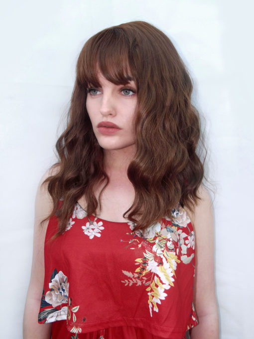 Anastasia is a light brown shade from roots to tips, with golden undertones. Styled in loose barrel curls that falls just below the shoulders in one length. Finished with a light blunt fringe. One of our natural looking wigs, that's versatile to style and easy to maintain.
