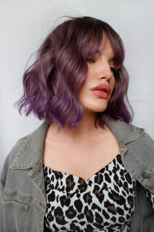 A mix of purples go into Bruised violet, brown shadowed roots give a natural feel to the look. Textured tousled waves are lightweight and manageable. This bob falls just above the shoulders with a blunt fringe to finish the look.