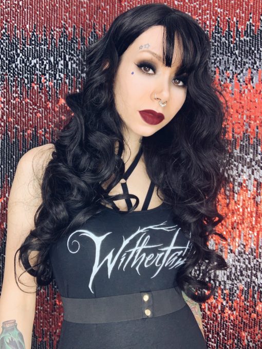 Black long curly wig. Dolores has a jet black hue from roots to tips. Styled in big curls that give lots of voloume to the look. A sleek light fringe completes the look.   